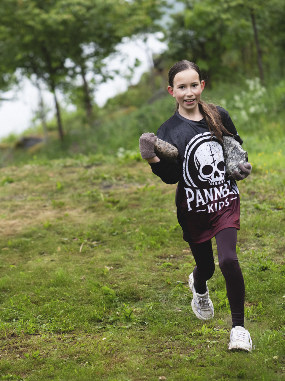 Deltagare springer med stenar i händerna under Pannben–Kids